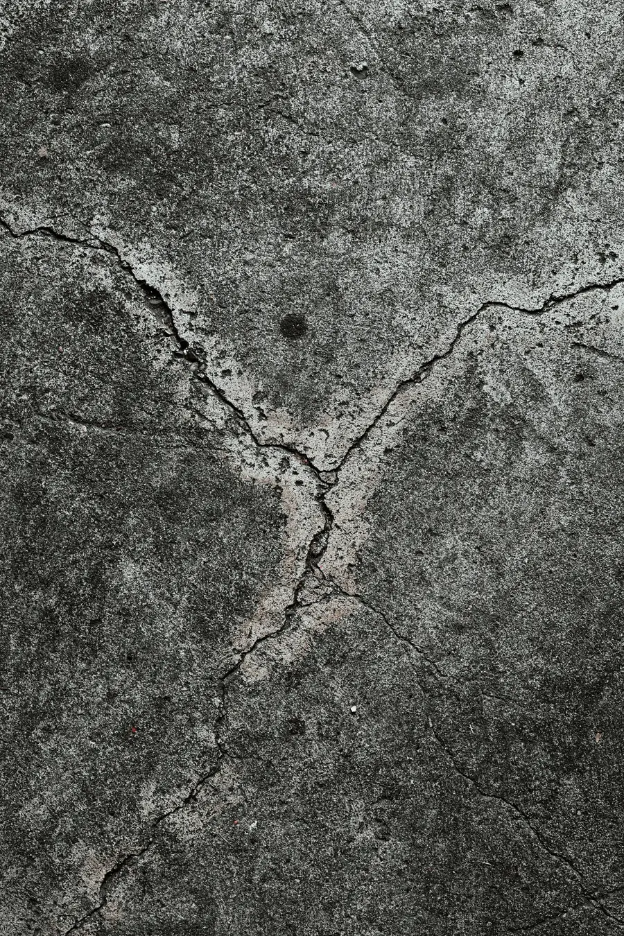 Wide branching crack across a grey concrete surface