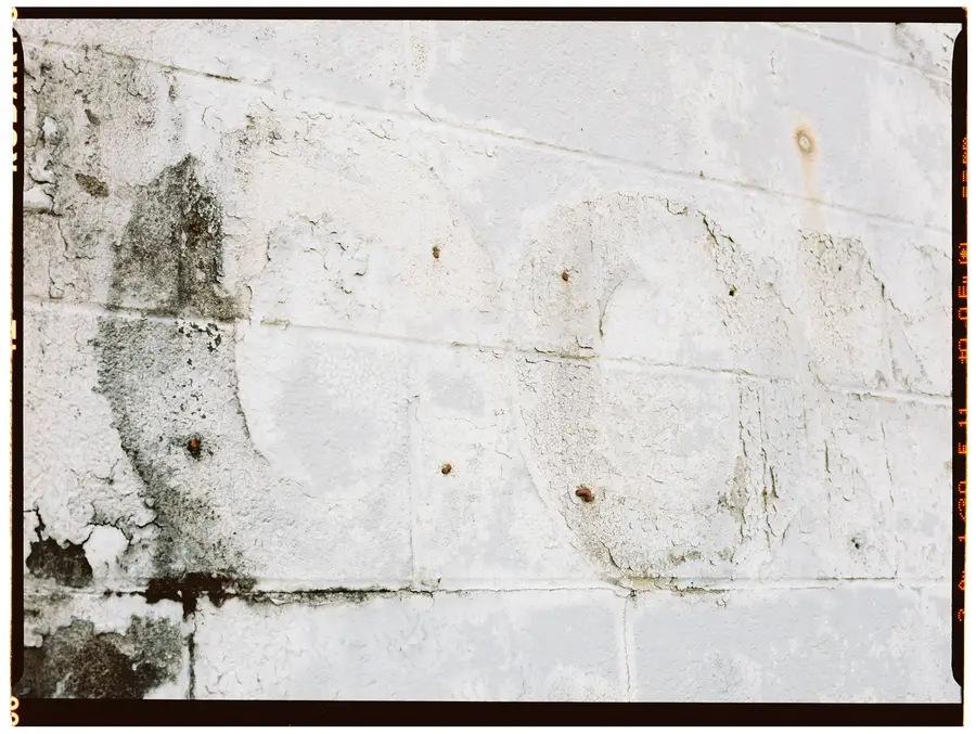 Damp patches and dark spots on a white painted wall