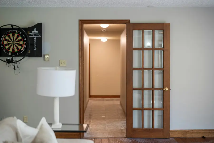 Finished basement hallway with a glazed door and warm lighting