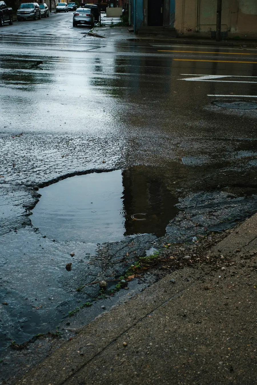 Large puddle on a gravel yard reflecting the sky