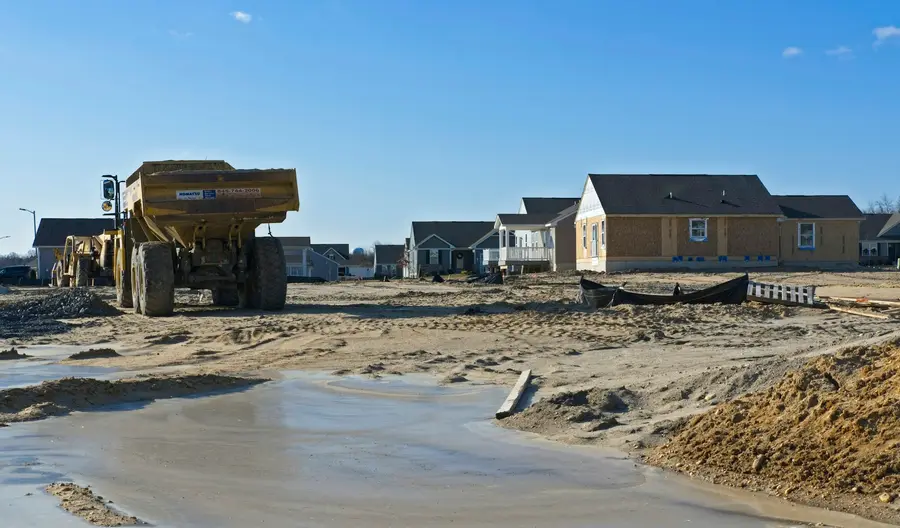 Water standing on a graded lot in a new subdivision beside a dump truck