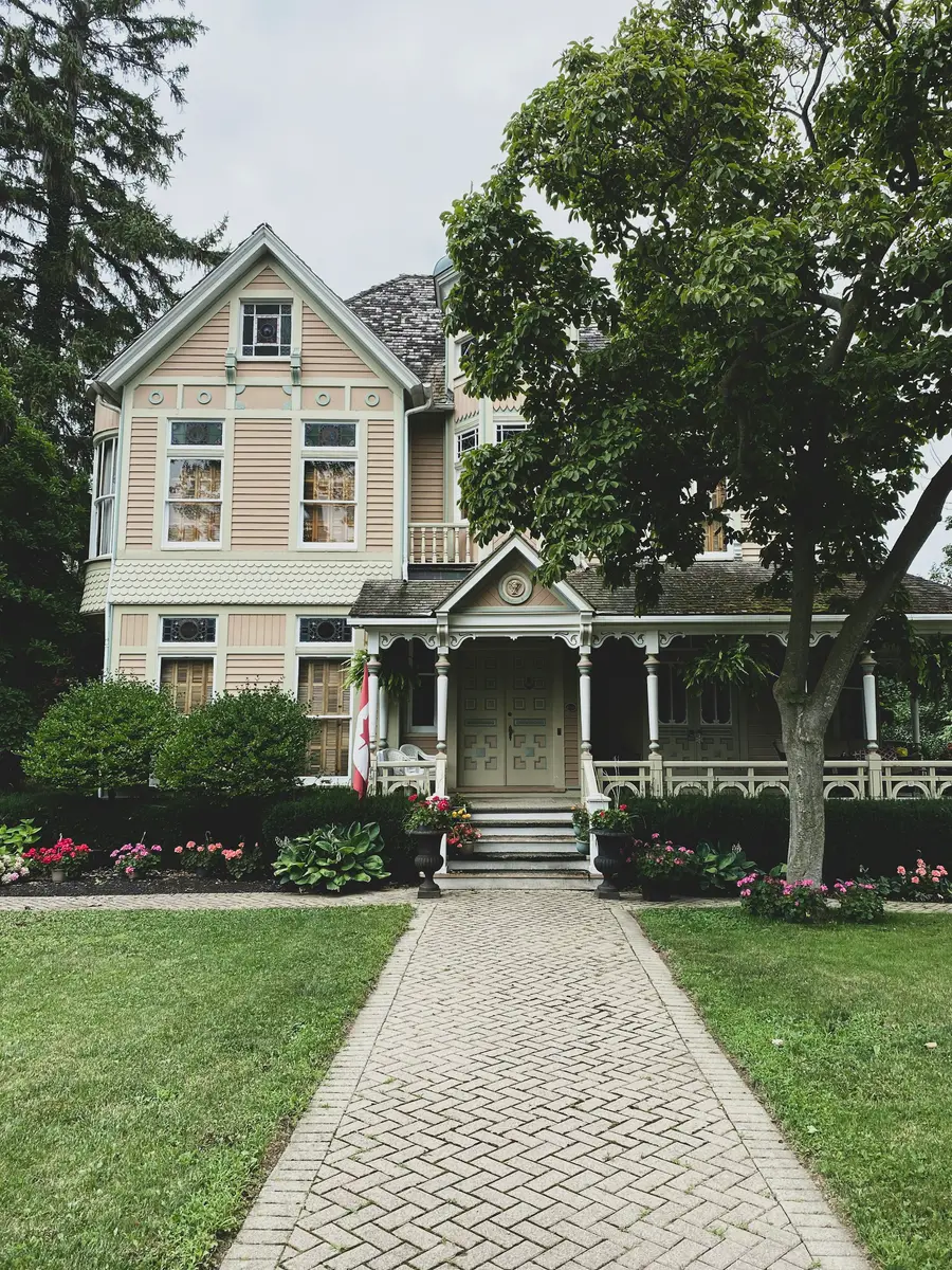 Cream-coloured Victorian house with gingerbread trim and a deep porch